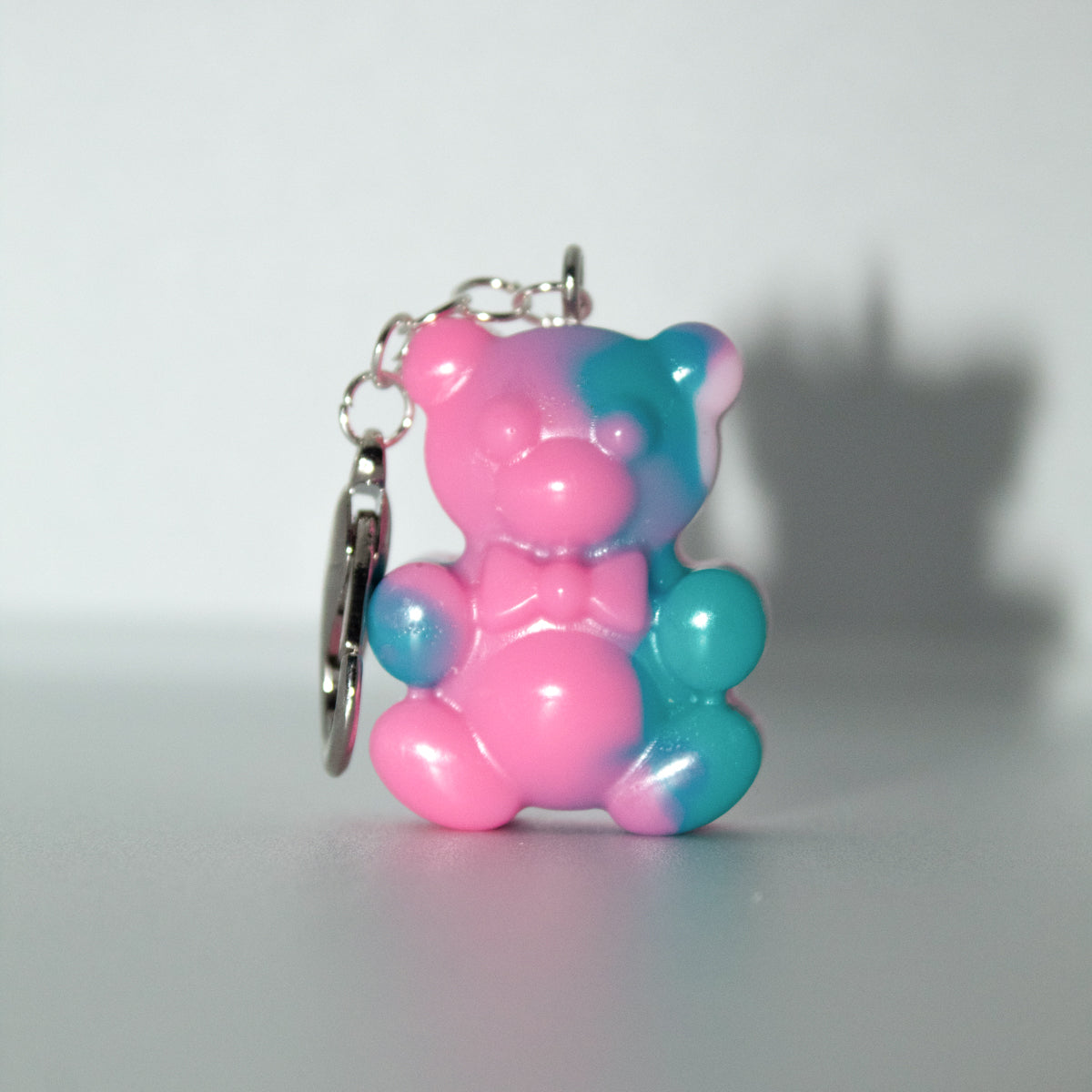 Pink and blue bear-shaped keychain on a white background