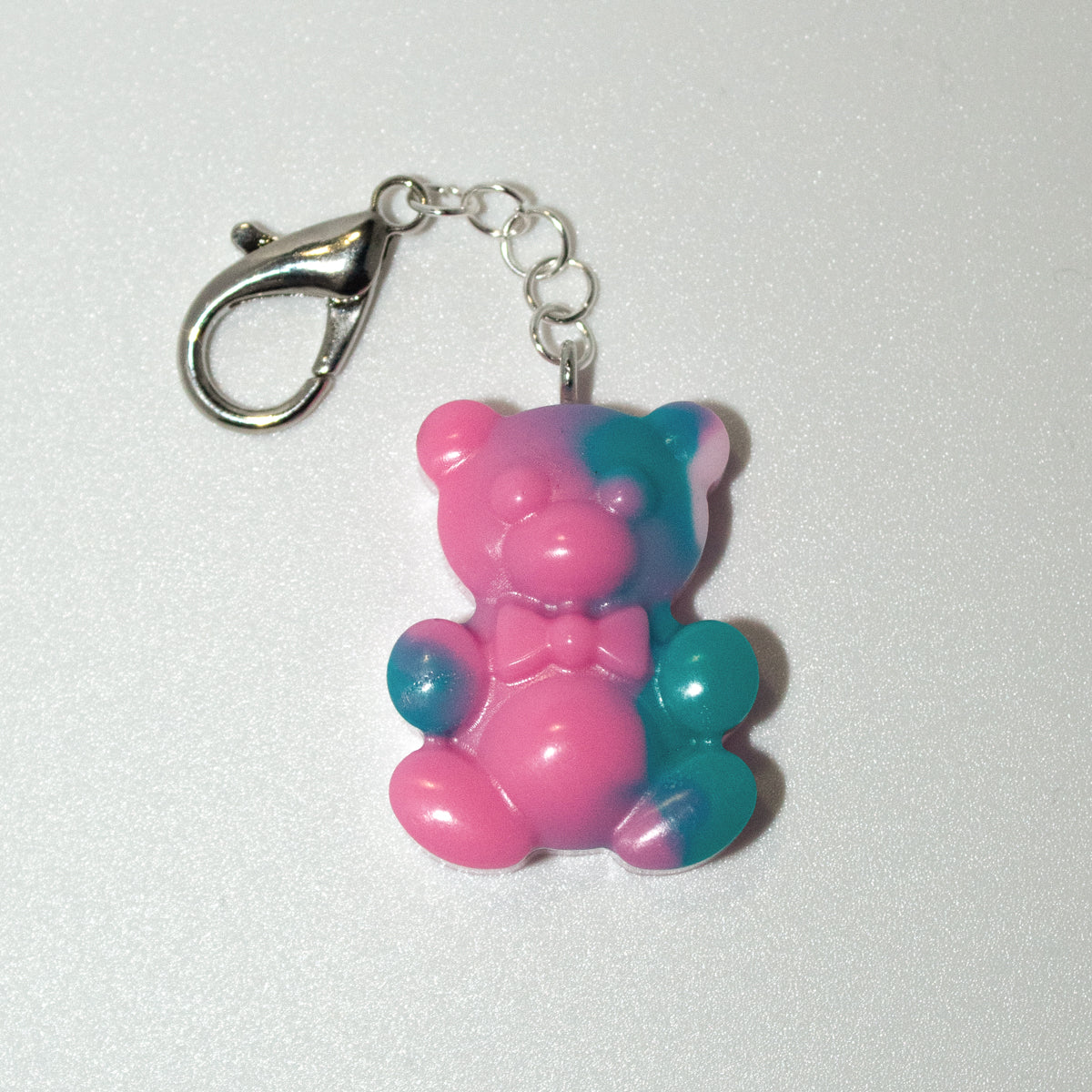 Pink and blue teddy bear keychain on a white background